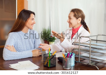 Young teenager patient listening the doctor and smiling at table