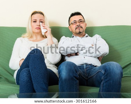 Sad man and unhappy crying woman having conflict at home