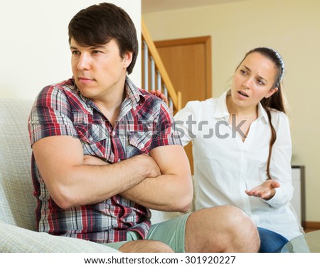 Young unhappy married couple having serious conflict at home