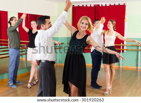 smiling group of people have fun while dancing waltz