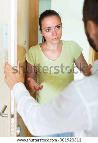 Upset  male and female talking at the door