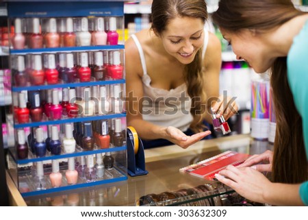 Store clerk serving purchaser with nail polish in the shopping mall