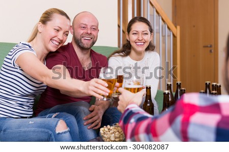 Happy people drinking beer  and laughing at home