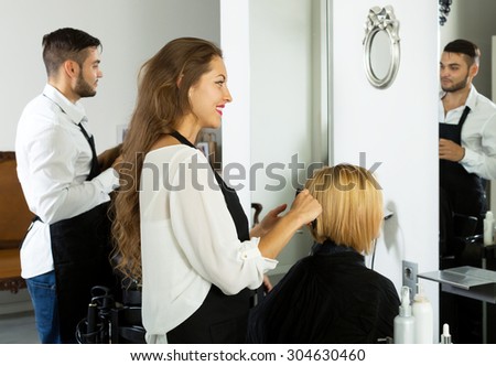 Hair stylist working on haircut for female client