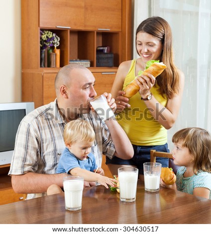happy family   having lunch with sandwiches at home together