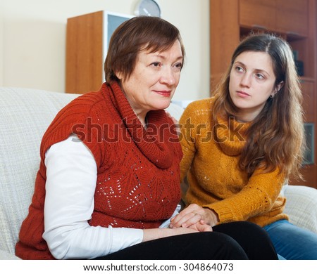 Adult girl asks for forgiveness from her mother. Focus on mature woman