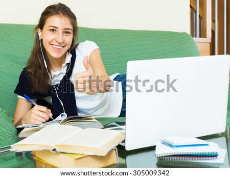 Smiling young woman college student study in living room