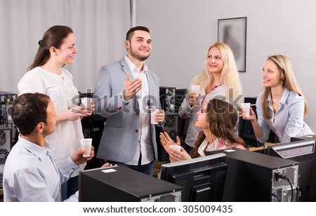 Group of happy colleagues drinking champagne at office