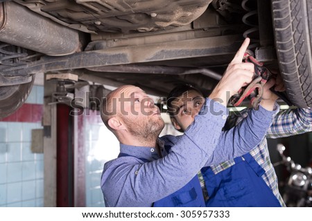 Two man fixing car tire leak