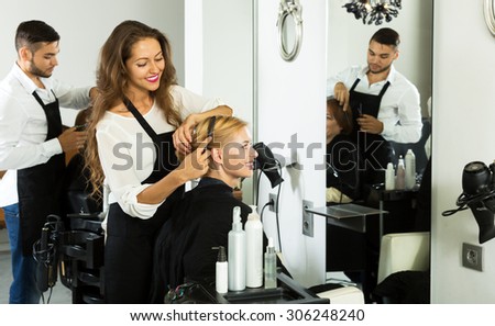 Hair stylist working on haircut for happy client
