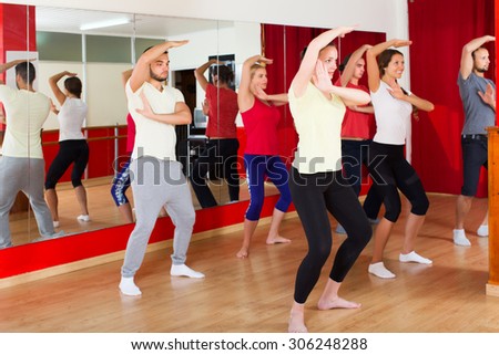 Active happy couples dancing modern style dance in class