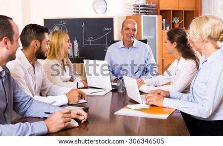 Smiling boss makes a presentation at a meeting in the office