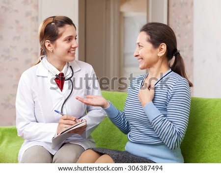 Happy doctor talks mature patient at medical hospital