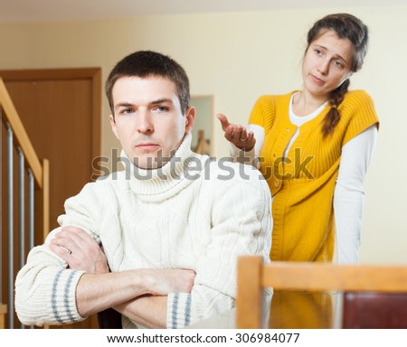 Family conflict. Sad ordinary man listening to  crying  depressed  woman at home