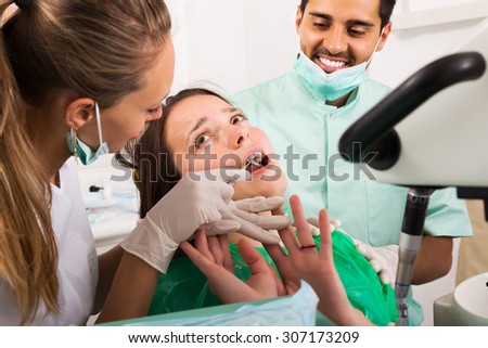 Terrified woman client and dental clinic crew during check up at dental clinic