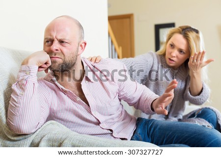 Casual family having quarrel in livingroom at home