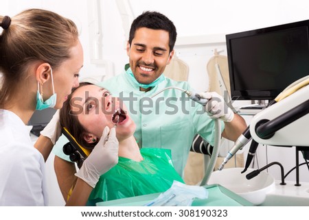 beautiful adult girl patient  treats teeth in the dental clinic. Focus on the patient
