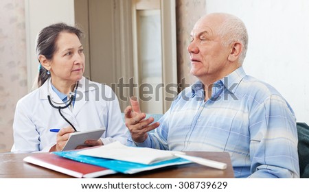 Medical consultation. Senior patient and doctor talking at table with documents