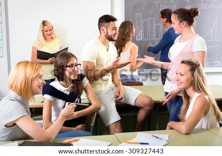 Group of students having informal conversation in classroom during a break