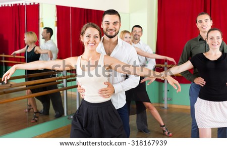 Tree happy young couples dancing waltz in dancing-class