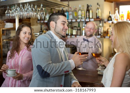 Happy bartender entertaining guests at the bar counter in bar