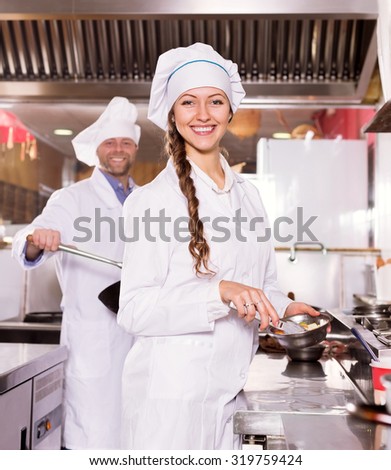 portrait young woman cook cooking at professional kitchen in the take-away  restaurant