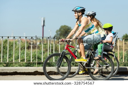 Bike ride young family with two kids in a summer day
