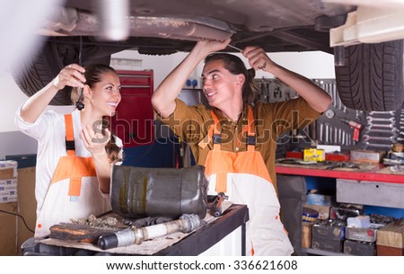 Positive mechanics crew repairing a broken car at garage