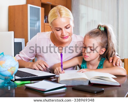 Portrait of happy adult woman and child having lesson indoors