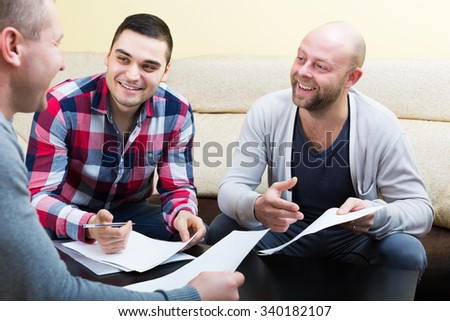 Satisfied clients sitting at the table with papers