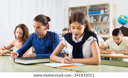 Group of young caucasian students studying in the classroom