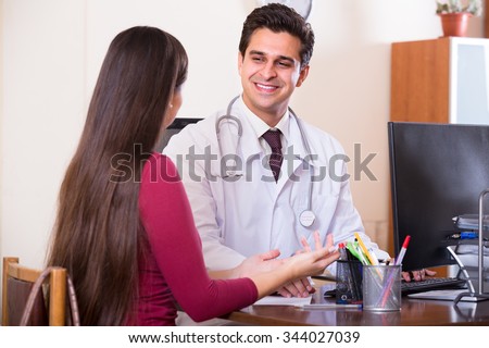 Positive doctor receiving ill patient at office and questioning