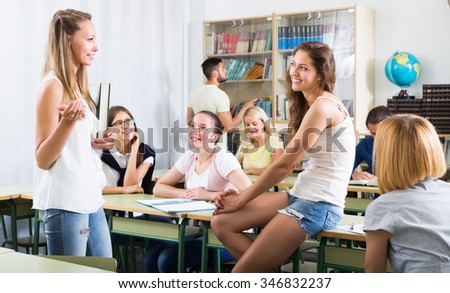 Positive young students having a conversation sitting in the classroom