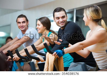 Group of young people training on exercise bikes in gym