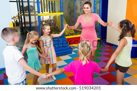 happy children dancing with teacher to music in class at school