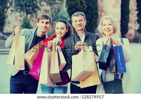 Family of four with shopping bags on city street