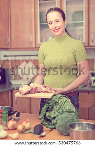 Portrait of smiling housewife preparing dinner for family indoor