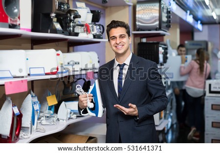 Smiling salesman working at small household appliances section