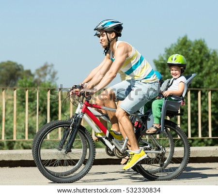 Happy family in casual clothes on the bikes with  kids