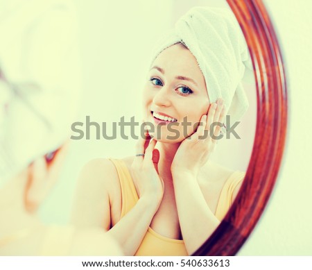 Young beautiful woman came from the shower and standing next to the mirror