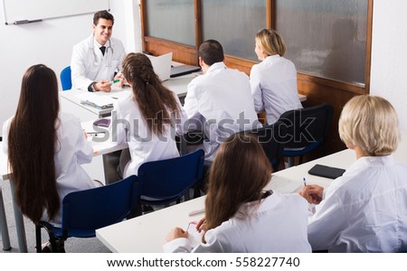 adult smiling health-care workers during educational program in medical school