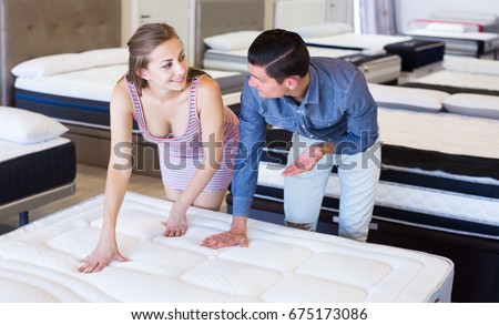 Happy Couple choosing mattresses in the store