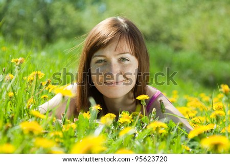 Happy   woman  relaxing outdoor in dandelion meadow