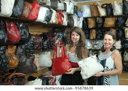 Two women chooses leather bag at  shop