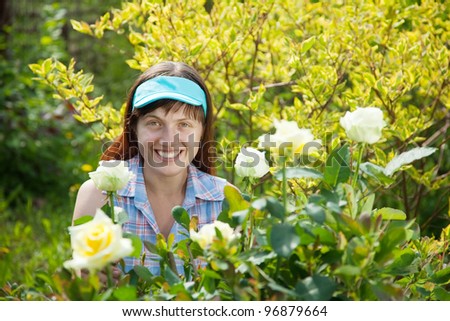 Happy young woman in the yard gardening