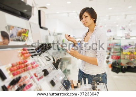 Girl chooses the cosmetic  at cosmetics  shop