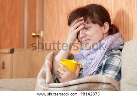 Young illness woman drinking hot tea in blanket