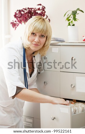 Female doctor searching for patient\'s records in clinic