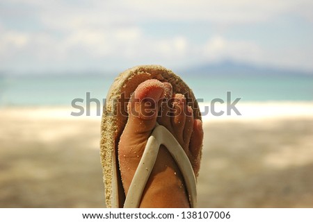 foot on sandal and sea