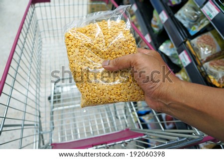 Close up of hand buying nuts at supermarket